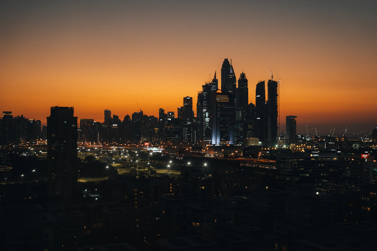 A city skyline at dusk under a warm orange sky
