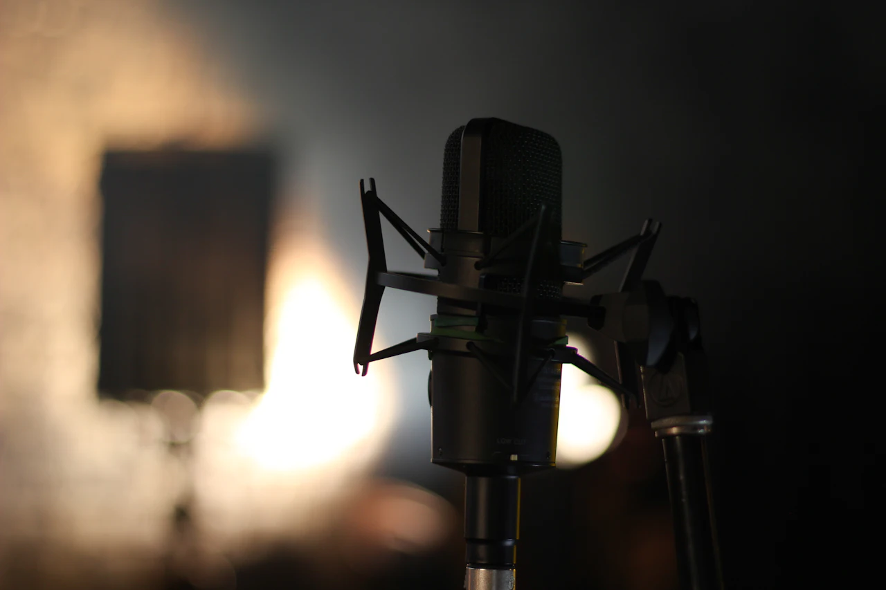 A studio microphone in low, warm light